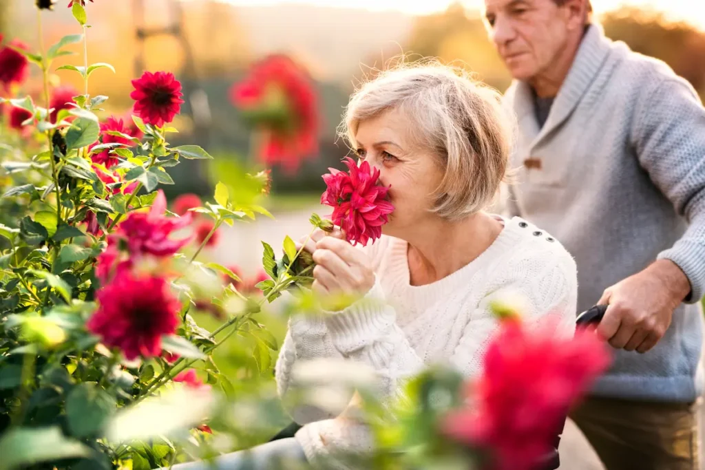 The Oaks of Garden Ridge | Senior woman smelling a rose