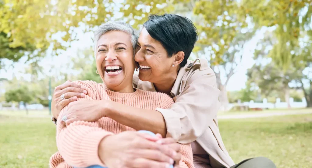 The Oaks of Garden Ridge | Senior friends hugging in the park